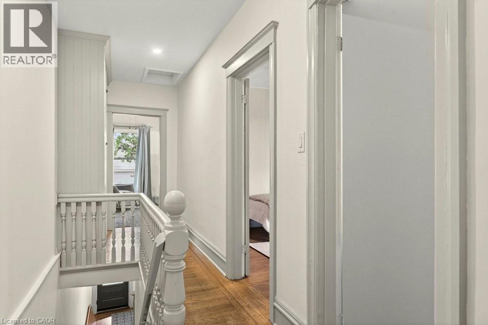 Upper-level hallway featuring wood-finish flooring, light-toned walls, and recessed ceiling lighting - 148 Dundurn Street N, Hamilton, ON