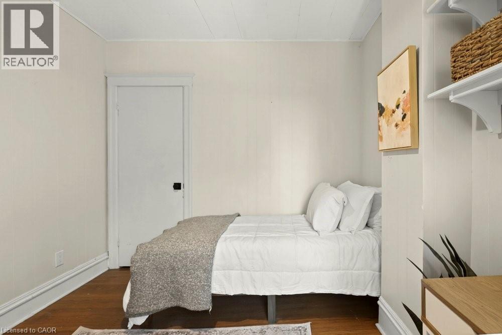 Hardwood-finish flooring complements light-toned walls and white trim - 148 Dundurn Street N, Hamilton, ON