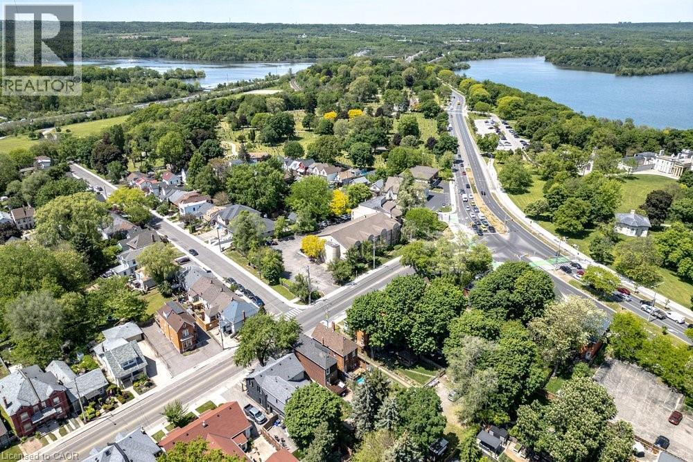 Aerial perspective of a developed neighborhood featuring various architectural styles, mature trees, and paved roads - 148 Dundurn Street N, Hamilton, ON