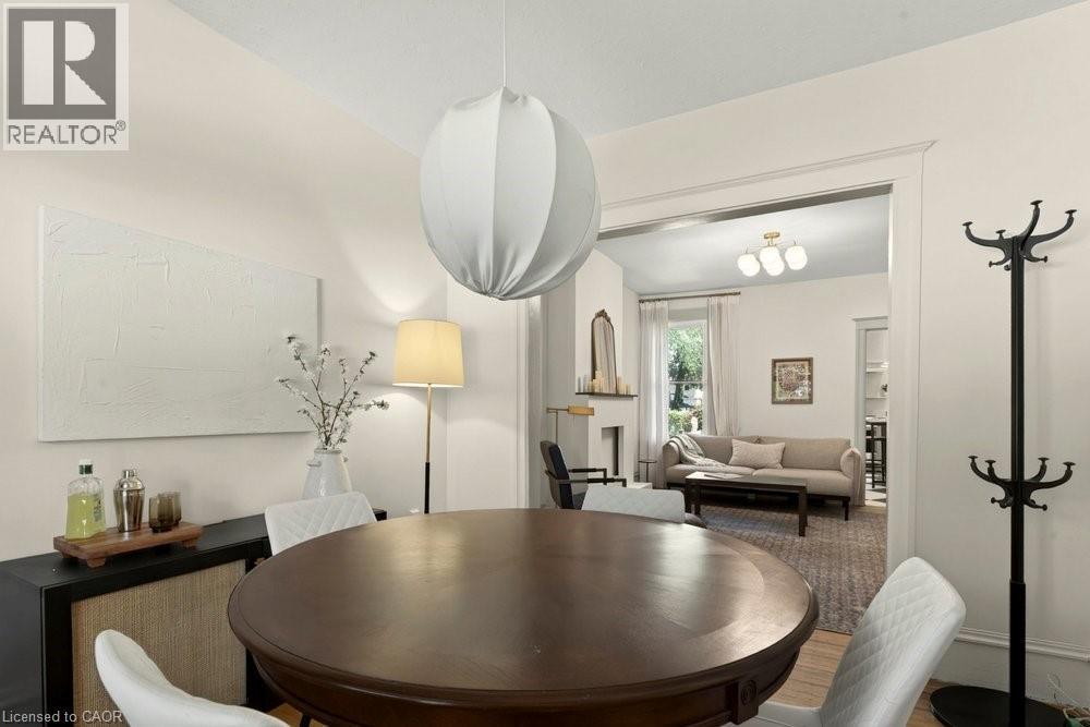 Dining area featuring a contemporary spherical pendant light and wood-finish flooring - 148 Dundurn Street N, Hamilton, ON