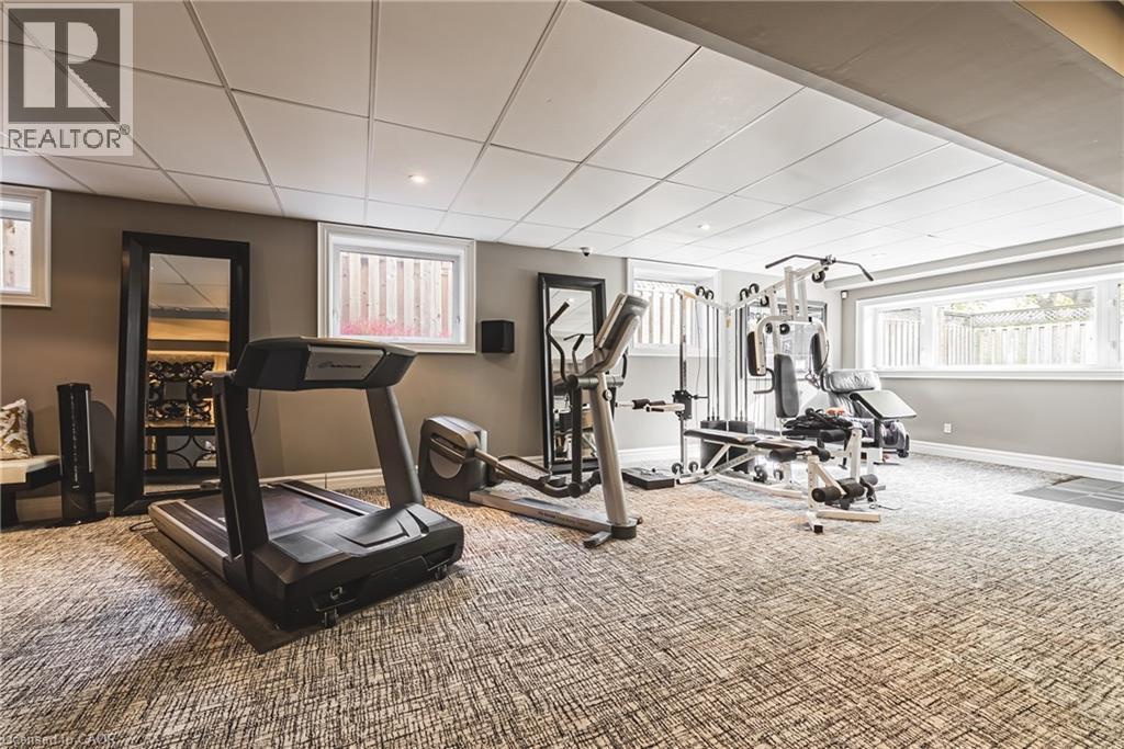 Spacious recreation room featuring patterned carpet flooring, recessed lighting, and multiple windows - 712 Highvalley Road, Ancaster, ON