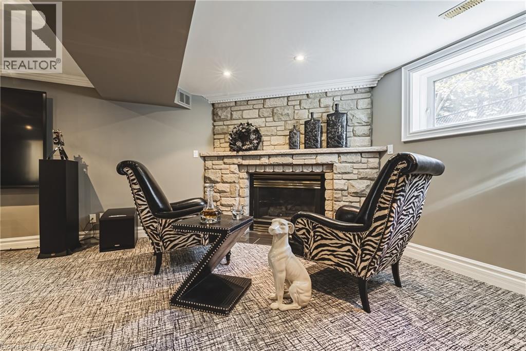 Stone-clad fireplace with mantel and hearth, accompanied by integrated recessed lighting, crown molding, a window with decorative privacy glass, and patterned carpeting - 712 Highvalley Road, Ancaster, ON
