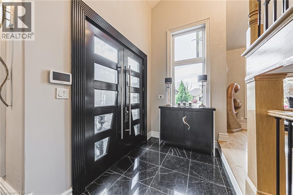 Entryway featuring black marble flooring, a tall transom window, and a dark wood double-door entry with frosted glass inserts and polished chrome hardware - 712 Highvalley Road, Ancaster, ON
