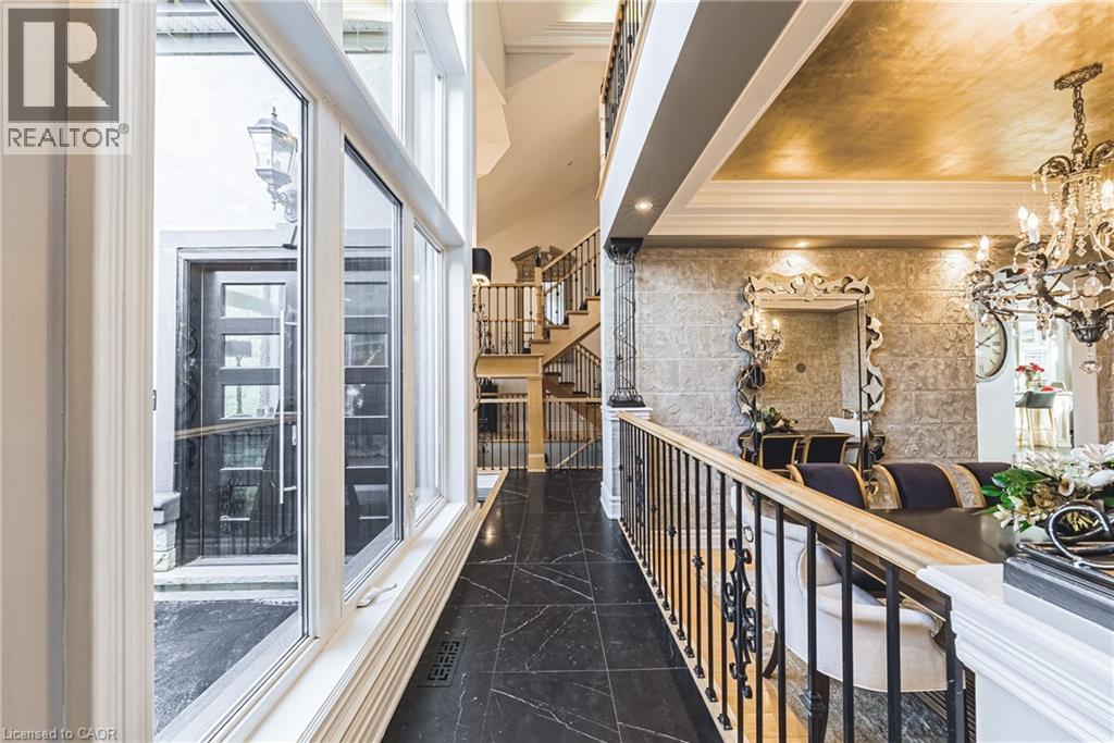 Grand entry foyer featuring a two-story window array, black tile flooring, and a decorative front door - 712 Highvalley Road, Ancaster, ON