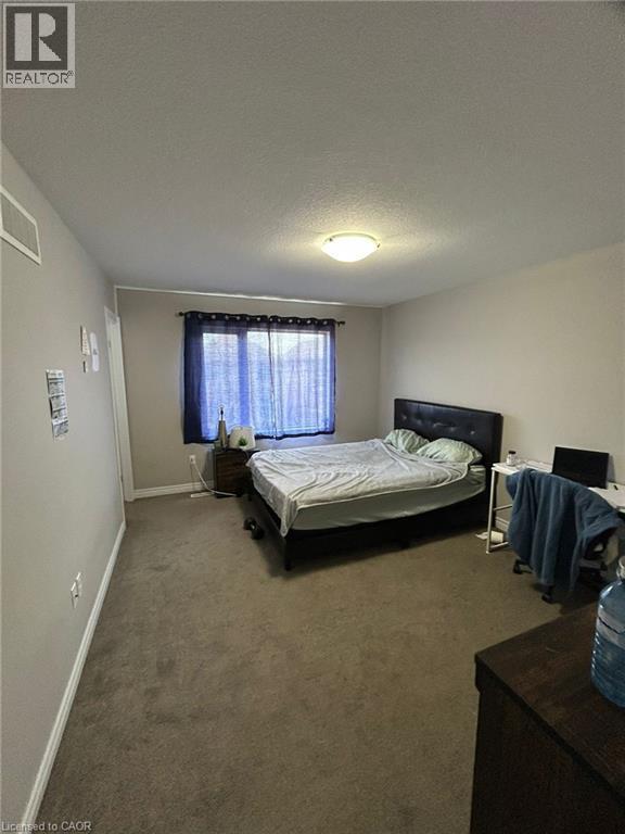 Carpeted room with a window featuring privacy sheers and dark drapes - 766 Freeport Street, London, ON