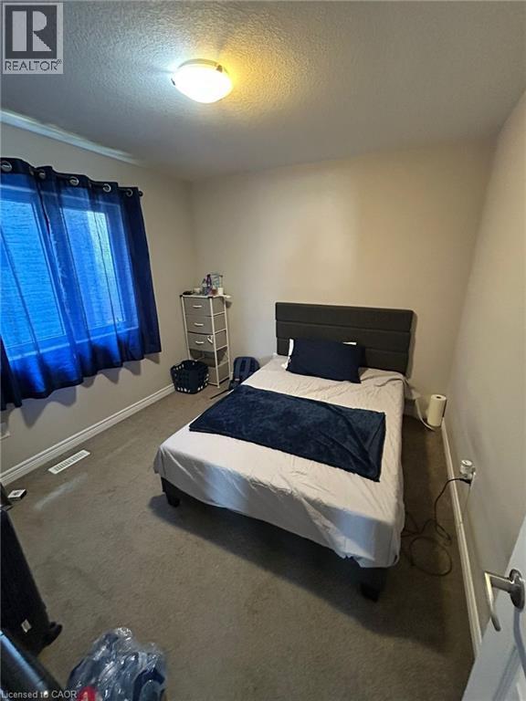 Carpeted room featuring a window with a white frame and light-colored walls - 766 Freeport Street, London, ON