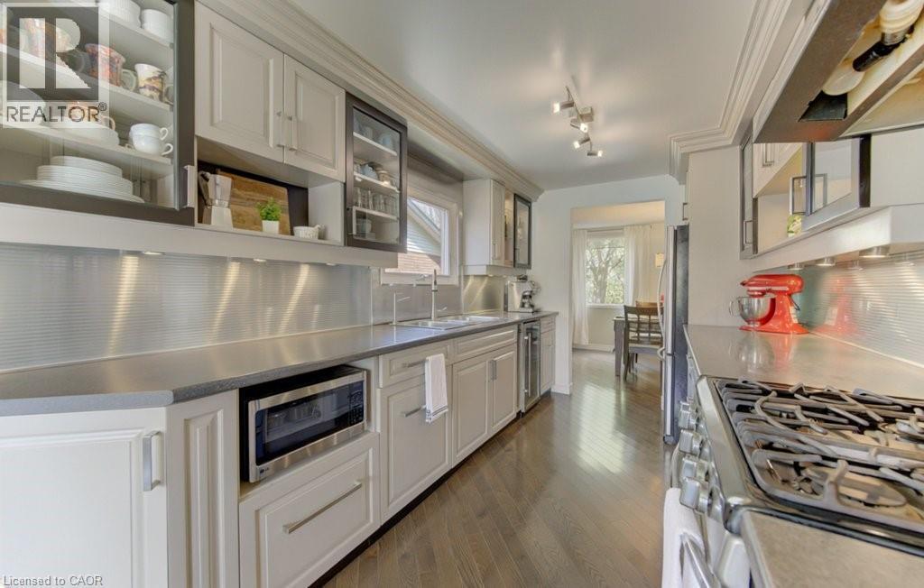 Contemporary kitchen featuring a stainless steel backsplash and dark wood-finish flooring - 108 Clearwater Crescent, Waterloo, ON