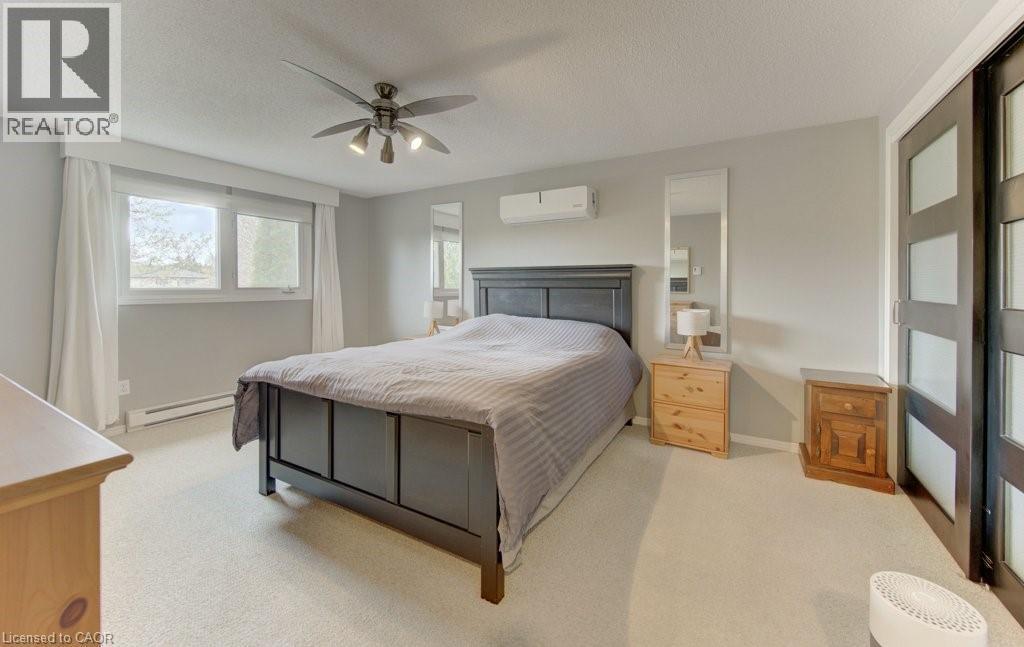 Spacious room featuring multiple windows with white window treatments, light neutral wall paint, and a textured ceiling - 108 Clearwater Crescent, Waterloo, ON