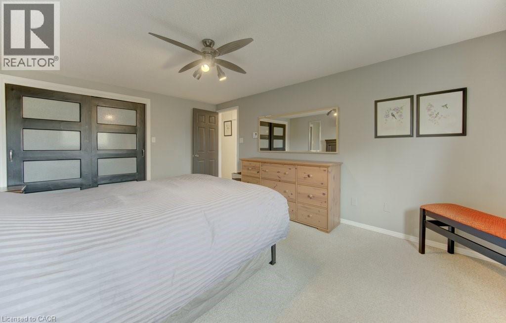 Bedroom featuring light-toned carpeting and a ceiling fan with integrated lighting - 108 Clearwater Crescent, Waterloo, ON