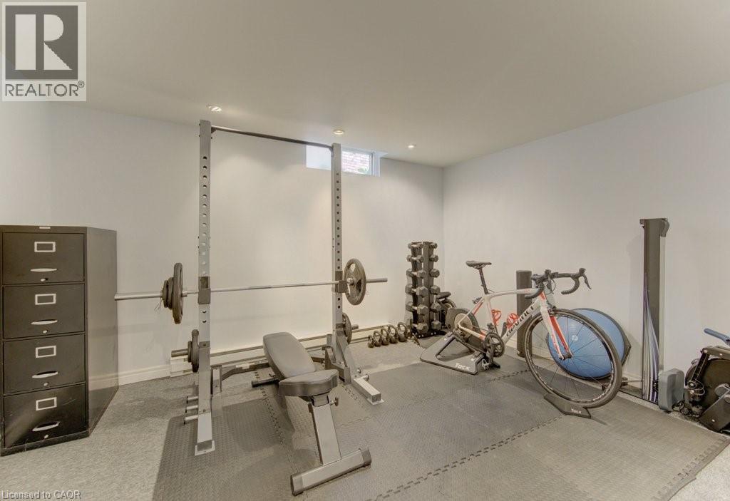 Dedicated fitness area featuring light-toned wall finishes, recessed ceiling lighting, and a window for natural light - 108 Clearwater Crescent, Waterloo, ON