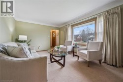Living room featuring light carpet and baseboards - 
