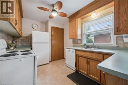 Kitchen with white appliances, backsplash, and light flooring - 