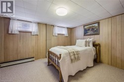 Carpeted bedroom featuring baseboard heating and wooden walls - 