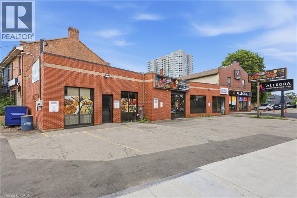Commercial building with brick exterior and multiple storefronts - 239 York Boulevard, Hamilton, ON
