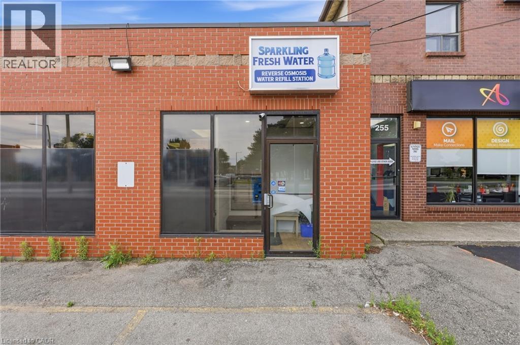 Brick-clad commercial storefront featuring prominent display windows and a glass entry door - 239 York Boulevard, Hamilton, ON