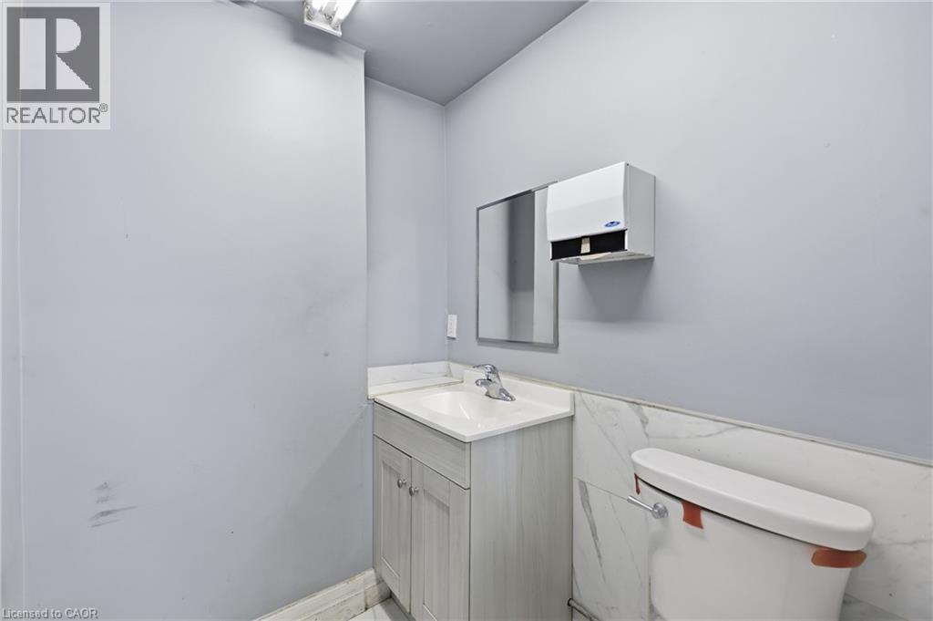 Bathroom featuring a single vanity with an integrated sink, polished chrome faucet, and under-cabinet storage - 239 York Boulevard, Hamilton, ON