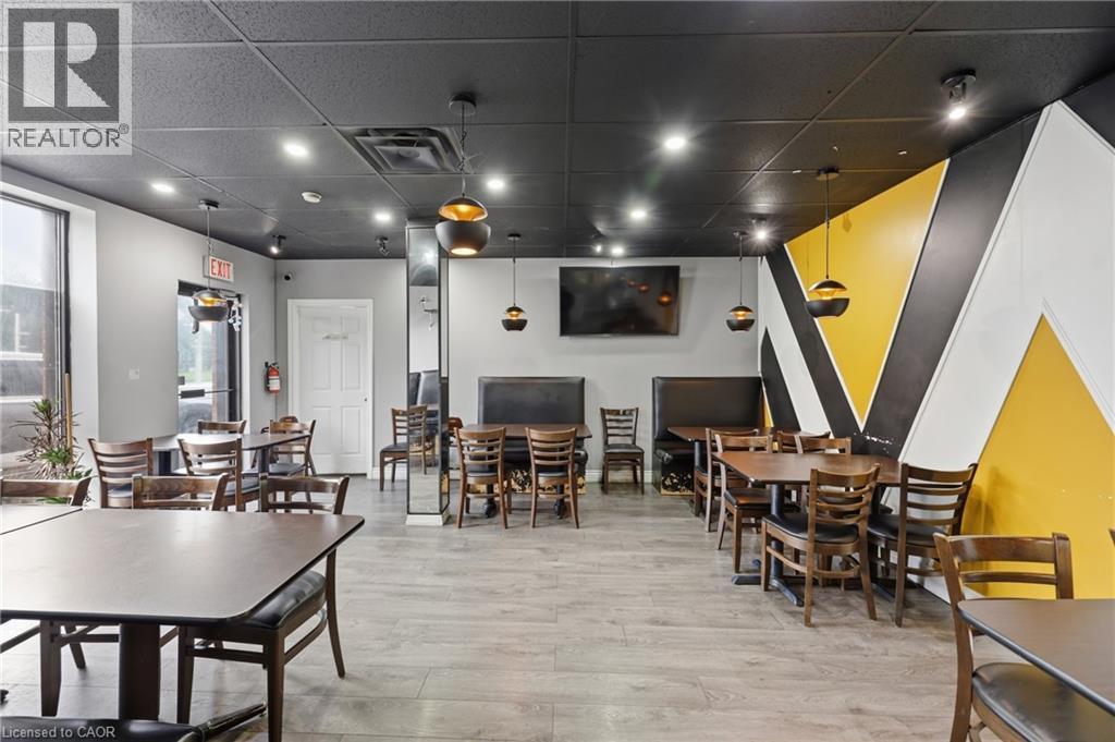 Spacious commercial interior featuring contemporary pendant lighting, recessed ceiling lights, and light wood-finish flooring - 239 York Boulevard, Hamilton, ON