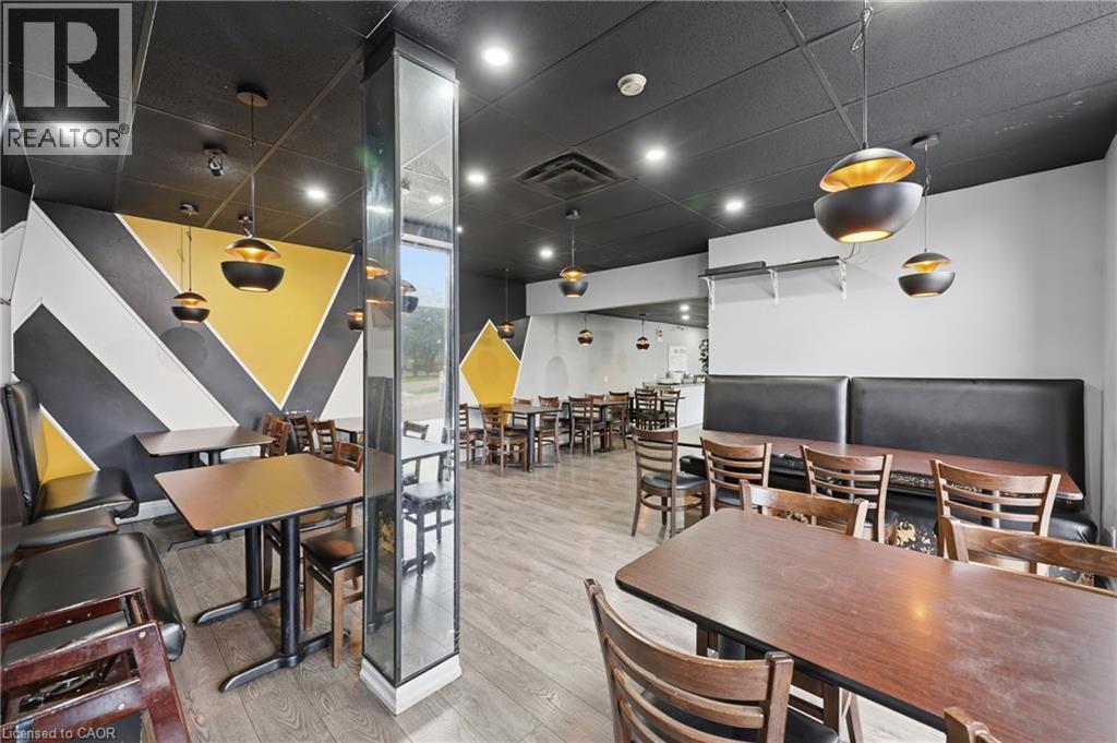 Spacious commercial interior featuring contemporary pendant lighting and a decorative accent wall with geometric patterns - 239 York Boulevard, Hamilton, ON