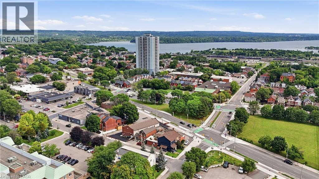 Aerial perspective of a mixed-use neighborhood featuring commercial buildings, residential properties, and a prominent high-rise structure - 239 York Boulevard, Hamilton, ON