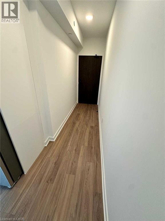Hallway featuring wood-finish flooring, white baseboards, and a recessed ceiling light - 2782 Barton Street E, Hamilton, ON