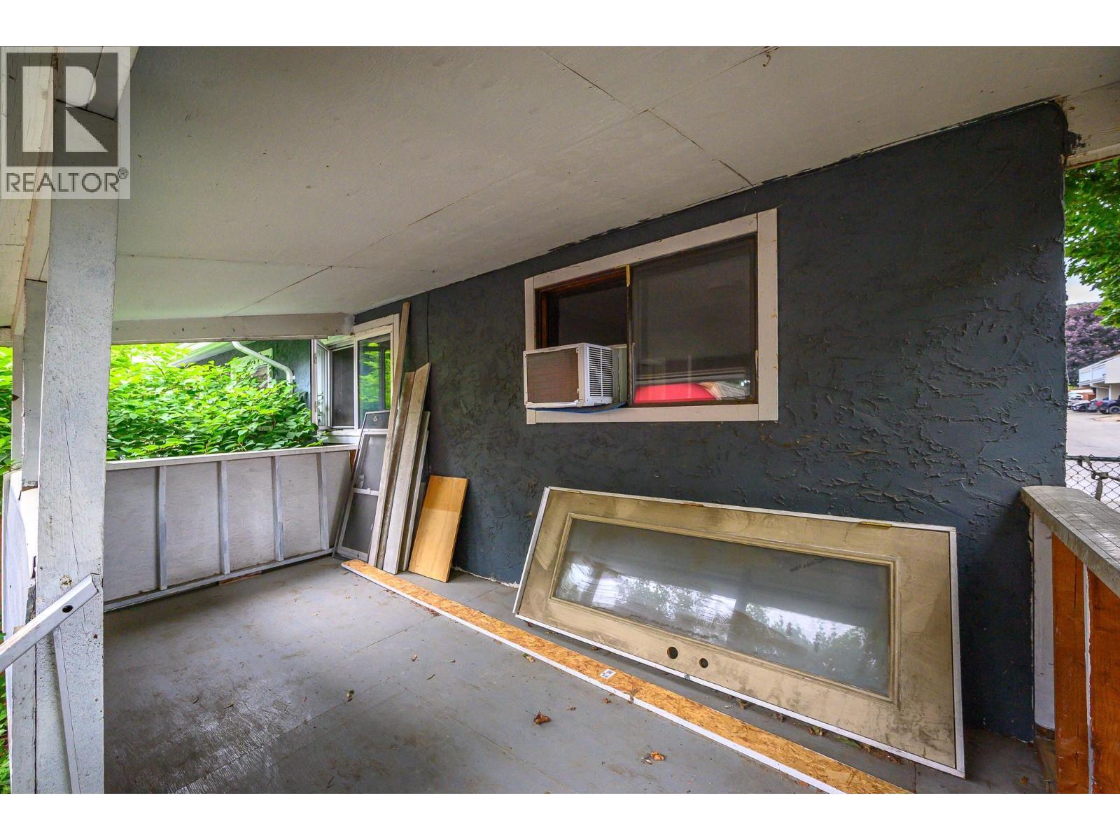Shady back deck with a new door and window waiting Buyer to install for direct deck access from house - 5008 Heritage Drive, Vernon, BC - Outdoor With Exterior