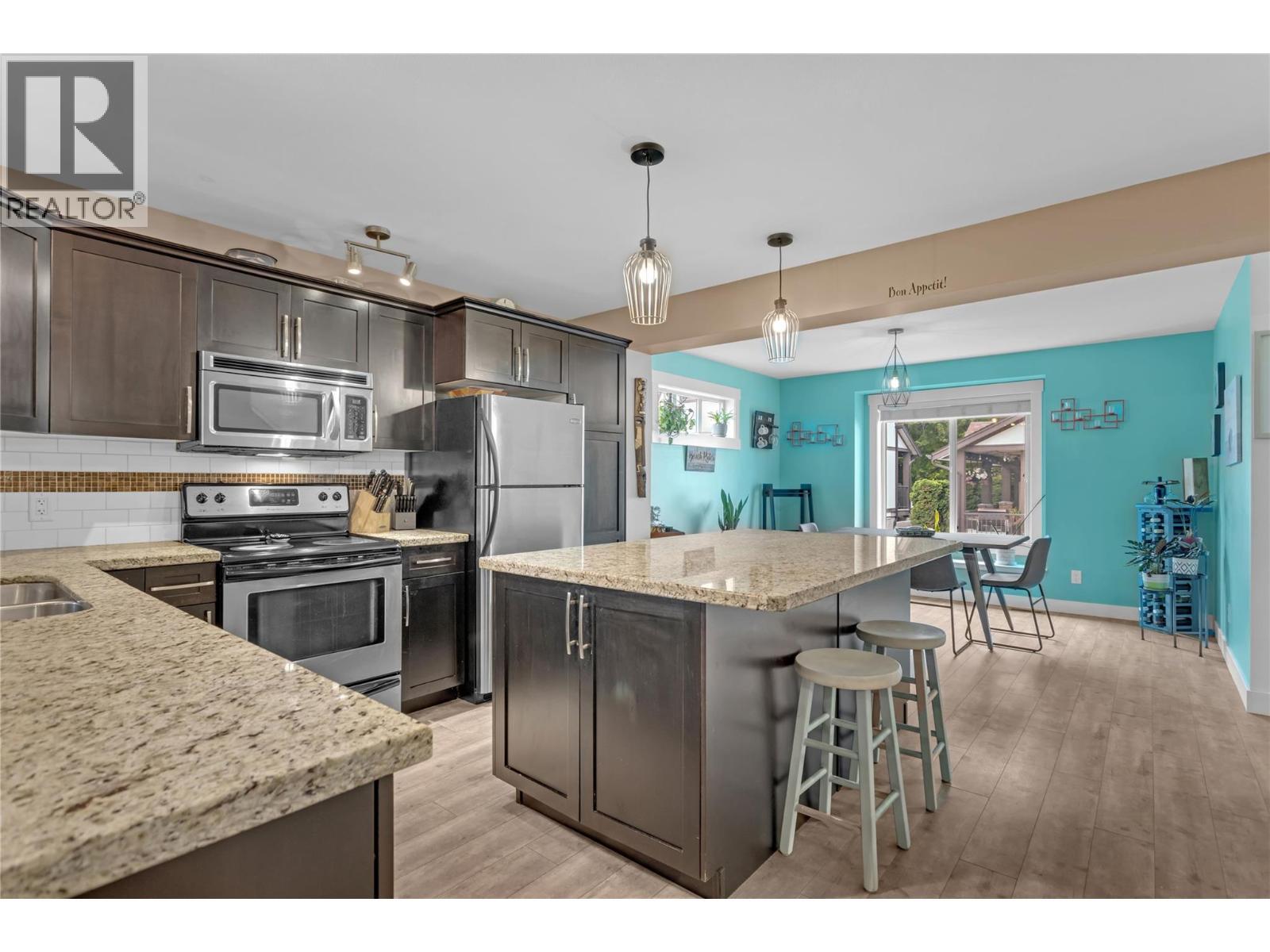 Kitchen with granite countertops and huge island. - 128-1651 Lynrick Road, Kelowna, BC