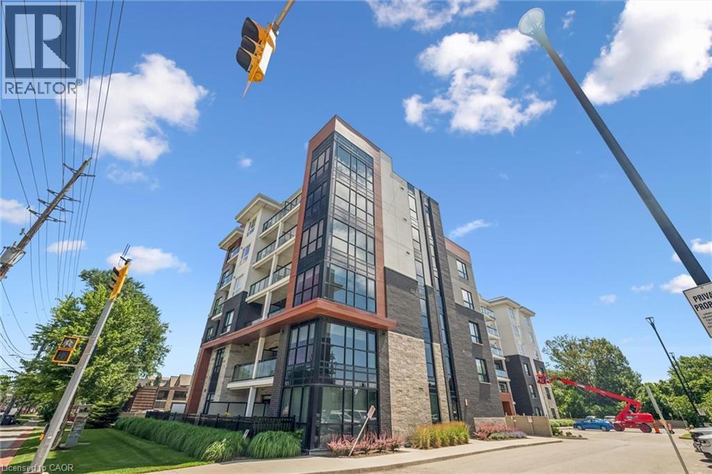 Modern multi-story building featuring expansive glazing, stone facade accents, and individual balconies with glass railings - 340 Plains Road E Unit# 507, Burlington, ON - Outdoor With Facade