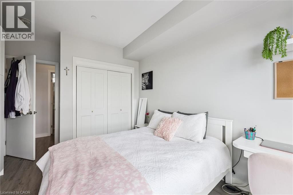 Bedroom featuring wood-finish flooring, light grey walls, and white trim - 340 Plains Road E Unit# 507, Burlington, ON - Indoor Photo Showing Bedroom
