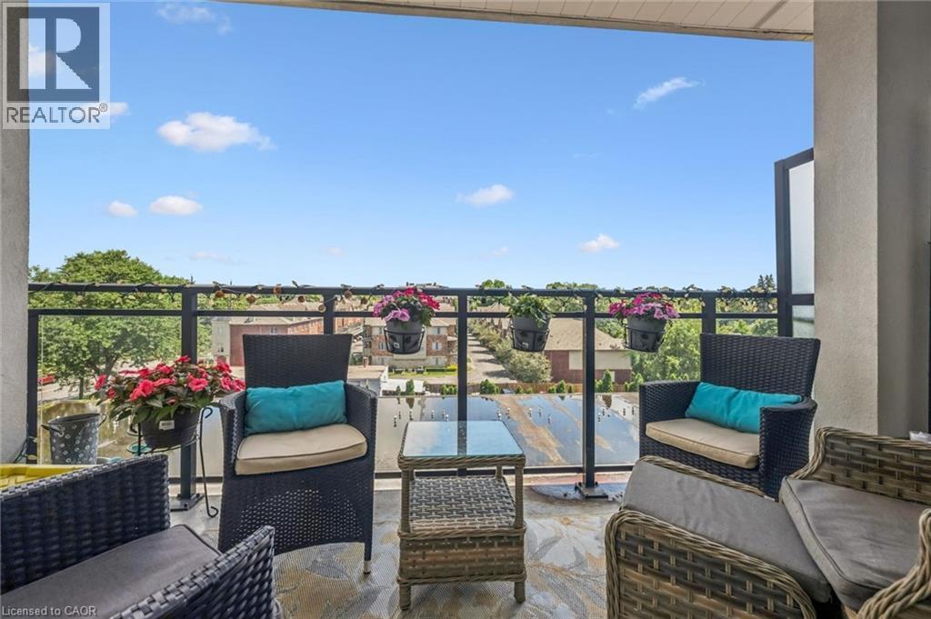 Spacious outdoor balcony featuring a glass and metal railing, stone-finish flooring, and ample room for seating - 340 Plains Road E Unit# 507, Burlington, ON - Outdoor With Balcony