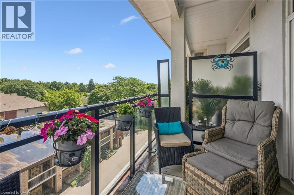 Outdoor balcony featuring a glass railing, solid privacy partition, and durable exterior flooring - 340 Plains Road E Unit# 507, Burlington, ON - Outdoor With Exterior