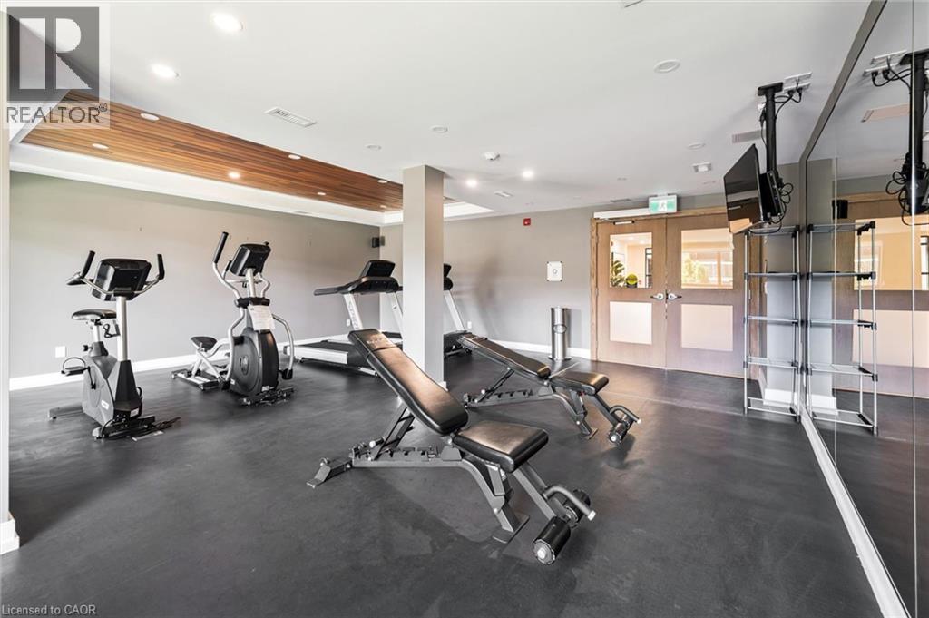 Indoor fitness area featuring dark gray flooring, a wood-finish ceiling accent, and recessed lighting - 340 Plains Road E Unit# 507, Burlington, ON - Indoor Photo Showing Gym Room