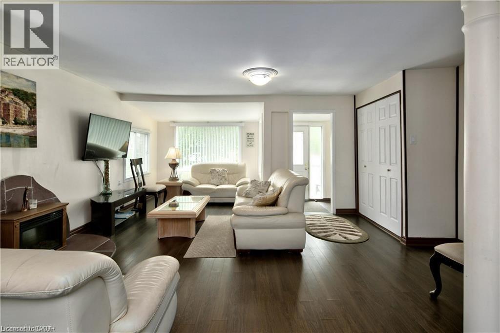 Open concept living area featuring dark wood-finish flooring, white walls, and a ceiling-mounted light fixture - 42 5Th Lane, Wasaga Beach, ON - Indoor Photo Showing Living Room
