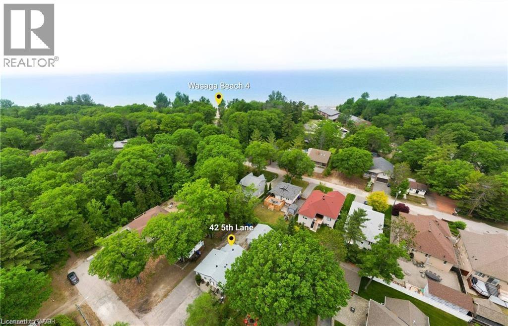 Aerial perspective showcasing the property at 42 5th Lane, nestled within a verdant treed setting - 42 5Th Lane, Wasaga Beach, ON - Outdoor With View