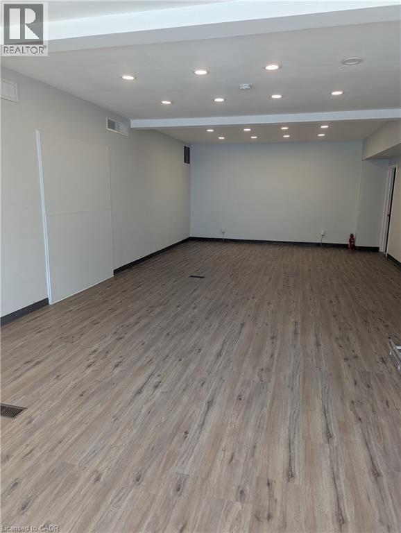 Spacious interior room featuring wood-finish flooring, recessed lighting, and light-toned wall paint - 499 Main Street E, Hamilton, ON
