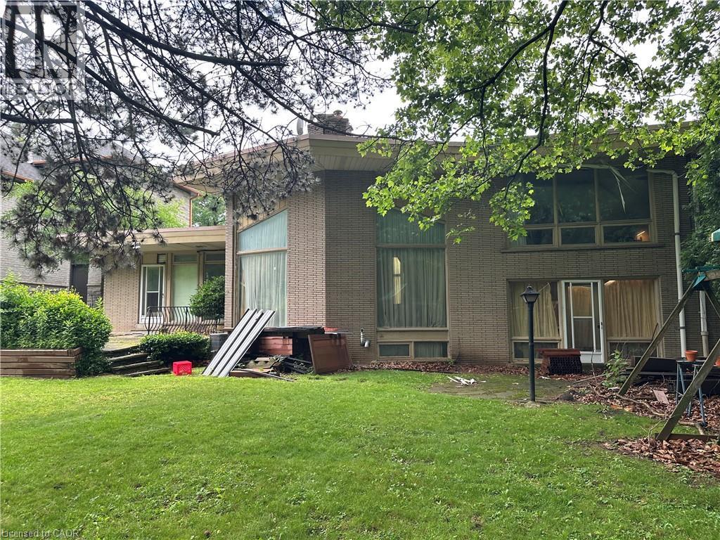 Brick exterior with multiple large windows and a rear patio - 11 Wilmont Court, Hamilton, ON