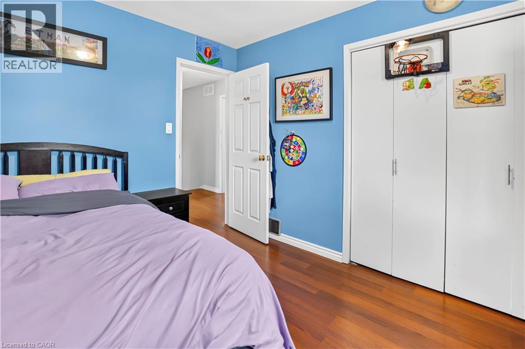 Bedroom with wood-finish flooring and a closet featuring bi-fold doors - 234 Thunderbird Drive, Cambridge, ON - Indoor Photo Showing Bedroom