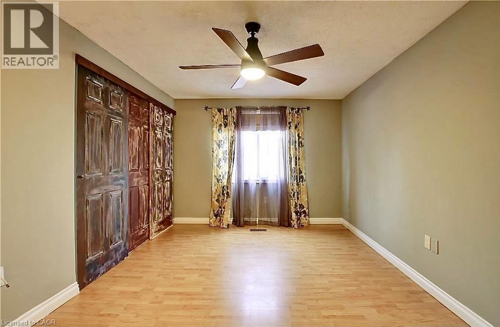 Bright room featuring light wood-finish flooring, a contemporary ceiling fan, and a window with natural light - 599 Upper Horning Road Unit# Main/Upper, Hamilton, ON