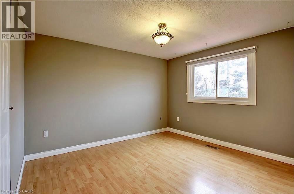 Room featuring light wood-finish flooring, neutral wall paint, and white baseboards - 599 Upper Horning Road Unit# Main/Upper, Hamilton, ON