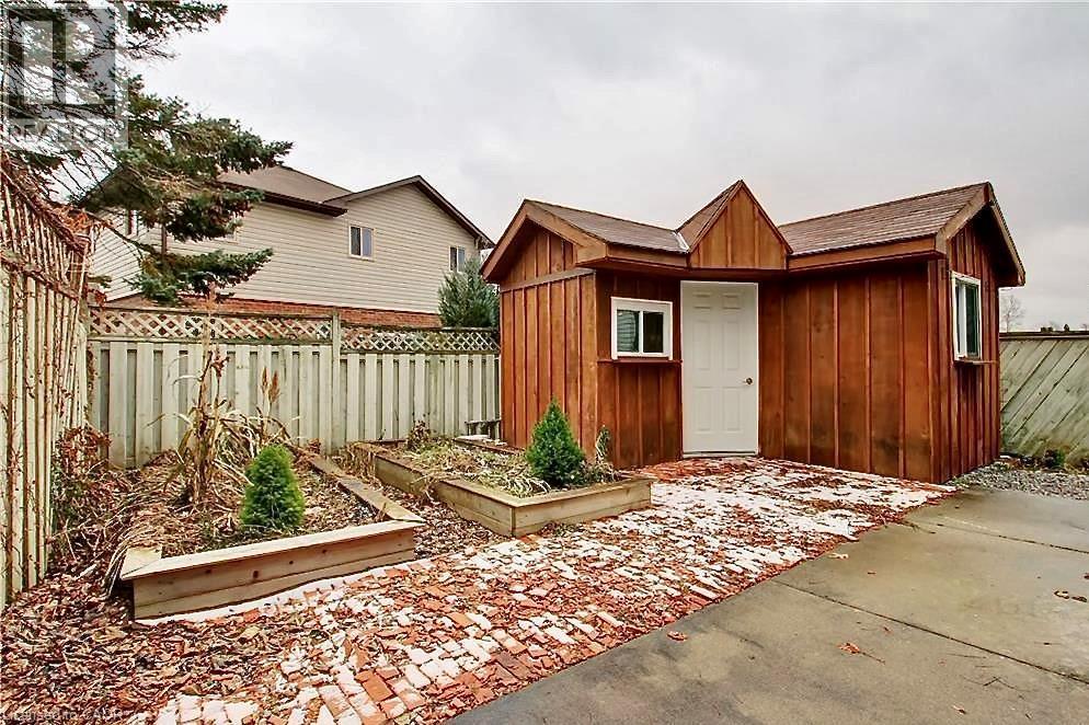 Freestanding wood-sided shed with a white door and two windows - 599 Upper Horning Road Unit# Main/Upper, Hamilton, ON