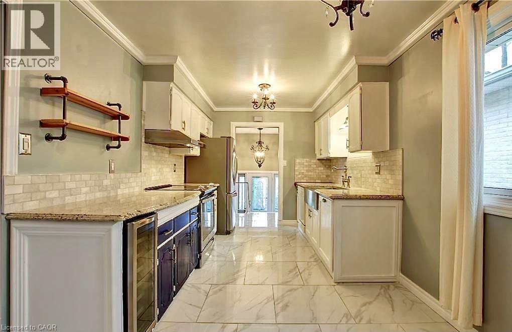 Galley kitchen featuring marble-patterned floor tiles, granite countertops, and a subway tile backsplash - 599 Upper Horning Road Unit# Main/Upper, Hamilton, ON
