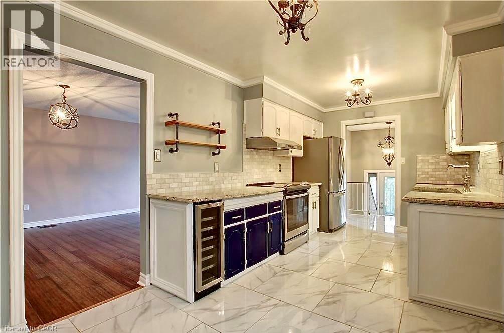Kitchen featuring white upper cabinetry, dark lower cabinetry, and stainless steel appliances - 599 Upper Horning Road Unit# Main/Upper, Hamilton, ON