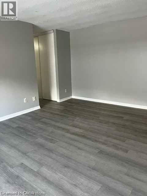 Gray wood-finish flooring complemented by white baseboards and light gray walls - 529 Parkside Drive Unit# 7, Waterloo, ON