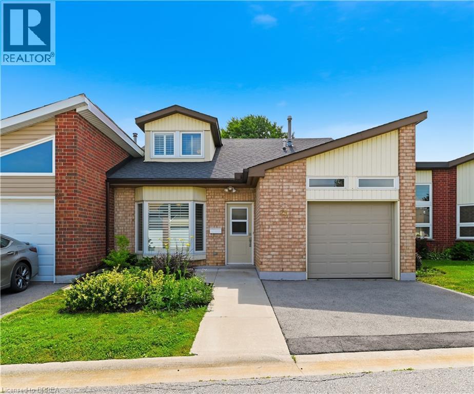 Brick exterior with an attached garage and a concrete driveway - 29 Archdeacon Clark Trail, Hamilton, ON
