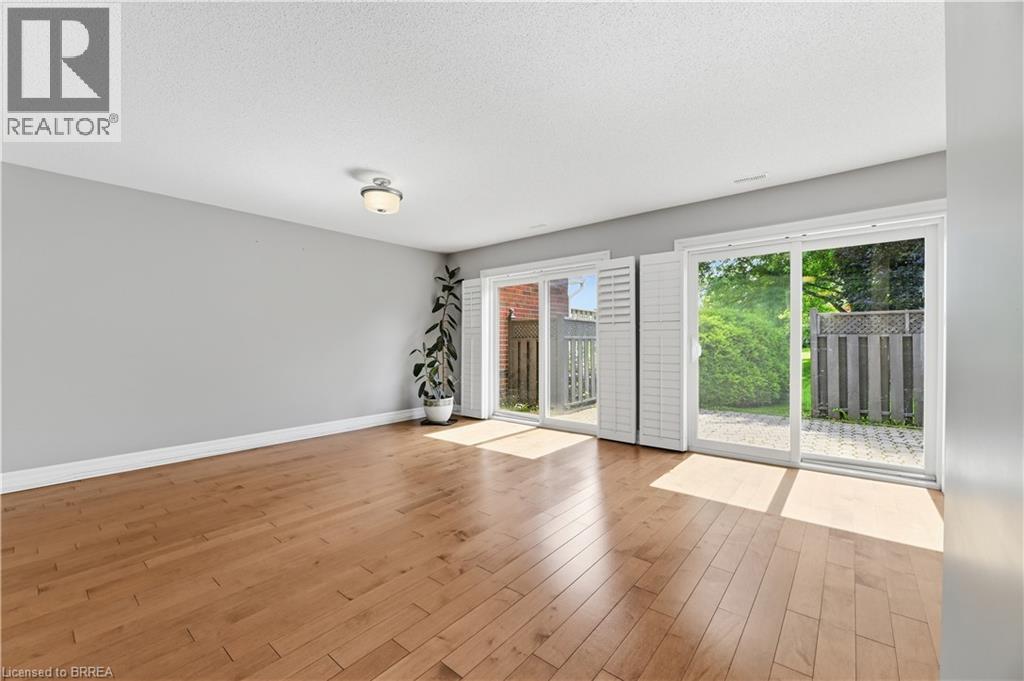 Bright interior featuring wood-finish flooring, light grey painted walls, and white trim - 29 Archdeacon Clark Trail, Hamilton, ON