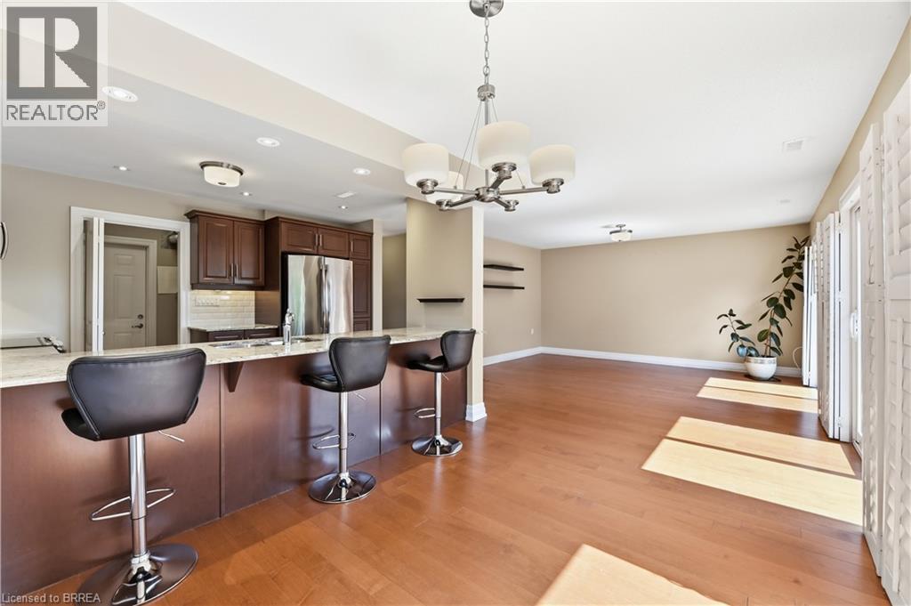 Open-concept living area featuring wood-finish flooring and neutral wall tones - 29 Archdeacon Clark Trail, Hamilton, ON