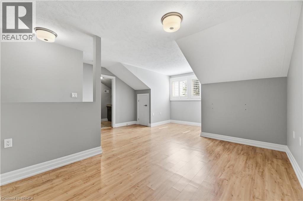 Open room featuring light wood-finish flooring and sloped ceilings - 29 Archdeacon Clark Trail, Hamilton, ON