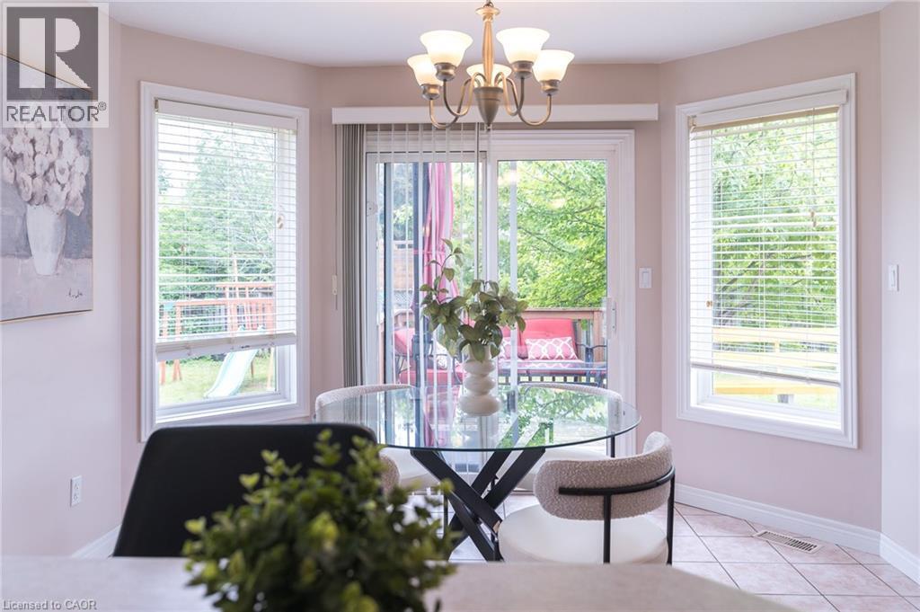 Dining area featuring a bay window with three large windows and a glass sliding door - 566 Avignon Place, Waterloo, ON