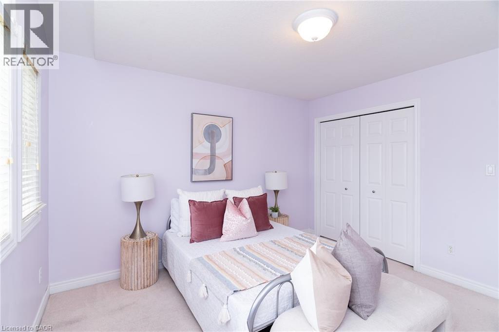 Light-toned bedroom featuring a double-pane window with blinds, bi-fold closet doors, and recessed lighting - 566 Avignon Place, Waterloo, ON