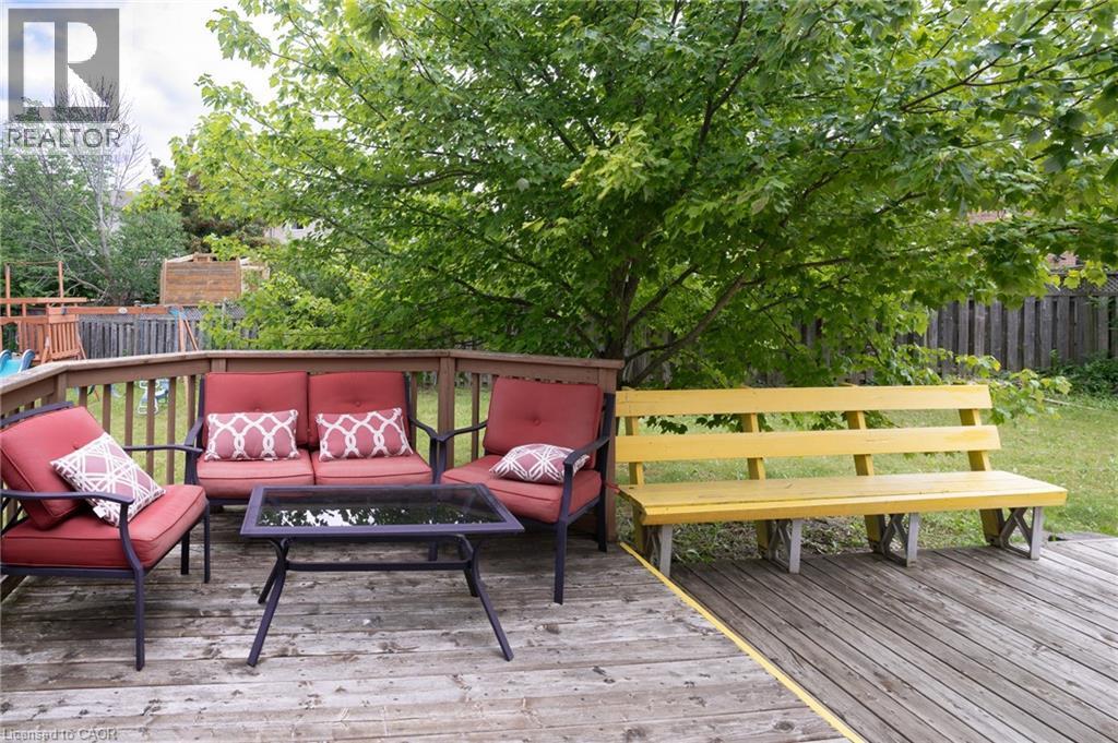 Expansive wood-plank deck featuring a wood railing and mature foliage - 566 Avignon Place, Waterloo, ON