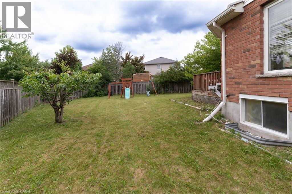 Expansive backyard with a manicured lawn, established perimeter fencing, and mature trees - 566 Avignon Place, Waterloo, ON